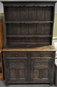A large, dark stained oak dresser with plate rack top of two shelves,