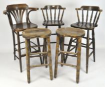 Three traditional wooden bar stools, two with spindle backs, all with turned tapered supports,