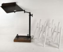 A late 19th/early 20th century oak and adjustable music stand together with four painted easels