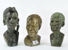 Three green and beige stone carved heads of African men, signed Eliot Zudizna,