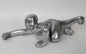 A white metal wall hanging in the form of a climbing figure,