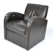 A modern dark brown leather armchair with curved arms,