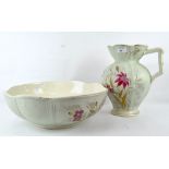 An early 20th century ceramic wash bowl and jug, decorated with pink floral scenes,