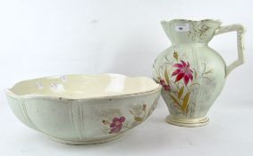 An early 20th century ceramic wash bowl and jug, decorated with pink floral scenes,