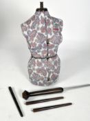 An Adjustoform dressmaker's dummy covered in paisley patterned fabric with wood and metal stand