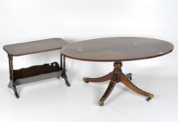 A mahogany oval coffee table, raised on a baluster column with four splayed legs on brass casters,