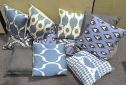 A collection of assorted cushions, most with vibrant blue and green covers,