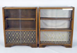 A pair of mid-century teak display cabinets, each with two sets of glass sliding doors,