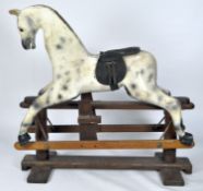 An early 20th century painted wooden rocking horse, on stand,