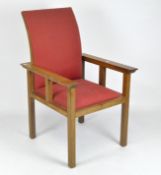 A 20th century Arts and Crafts style light oak arm chair with red upholstery,