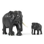 A large carved ebony and ivory inlaid elephant and baby elephant, each with ivory tusks,