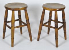Two contemporary stained hardwood stools, with turned tapering legs,
