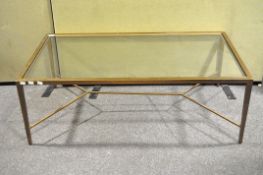 A contemporary gold sprayed metal coffee table with glass insert,