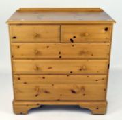 A modern pine chest of five drawers with turned knobs,