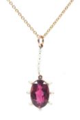A yellow metal garnet and seed pearl pendant on a 9ct marked chain link necklace. 2.6g.