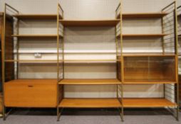 A Ladderax shelving unit, mid-century, with four gilt metal uprights,