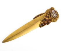 An Art Nouveau brass paper knife, circa 1900, the handle formed as a stylised dragonfly,