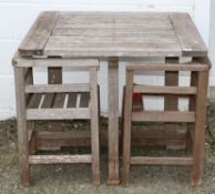 A Heals wooden garden table and two chairs, of slatted construction and square section,