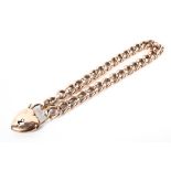 A gold curb link bracelet with heart locket both stamped 10. 14g.