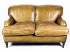 An olive green leather two-seater leather sofa, on turned wooden legs, 20th century,