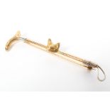 A 9ct gold fox head and whip bar brooch. 3.8g.