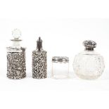 Four silver topped or mounted glass bottles, one of globular form, a pierced and embossed pot,