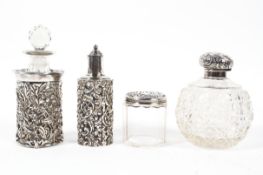 Four silver topped or mounted glass bottles, one of globular form, a pierced and embossed pot,