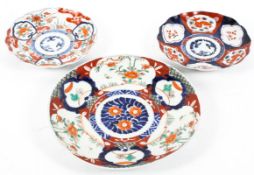 Three Japanese Imari pattern dishes, each painted with panels of flowers and animals,