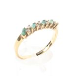 An 18ct gold emerald and diamond ring line set with alternate step cut emeralds and single cut