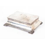 An Edwardian silver cigarette box of flowing sarcophagus form, with engraved initials to lid,