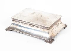 An Edwardian silver cigarette box of flowing sarcophagus form, with engraved initials to lid,