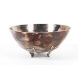 A sterling silver planished bowl of circular form raised on three cast leaf supports by AEG