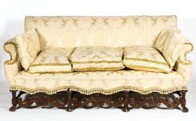 A Caroleon style upholstered three-seater sofa, in cream damask fabric with fringed tassles,