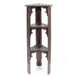An Arts and Crafts carved oak three tier stand in the style of the Scottish School of Arts,