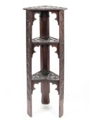 An Arts and Crafts carved oak three tier stand in the style of the Scottish School of Arts,