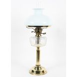 An Edwardian brass-mounted oil lamp and two shades, the lamp on reeded column base,