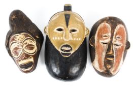 Three West African Tribal masks, with carved and painted features, 37 cm long max.