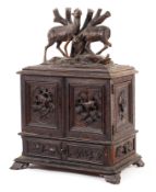 A large carved Black Forest jewellery box, late 19th century, the top carved with deer finial,
