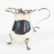 A late Victorian silver cream jug, with foliate embossed border, raised upon three lion paw feet,