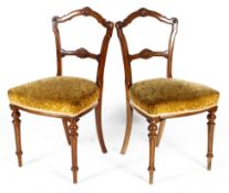 Four Victorian carved walnut dining chairs, late 19th century, each with scroll shaped back rail,