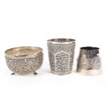 Three Indian white metal vessels, comprising a highly detailed repousse beaker,