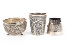 Three Indian white metal vessels, comprising a highly detailed repousse beaker,