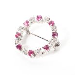 A 9ct white gold wreath brooch set with single cut rubies and illussion set diamonds. 2.6g.