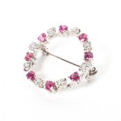 A 9ct white gold wreath brooch set with single cut rubies and illussion set diamonds. 2.6g.