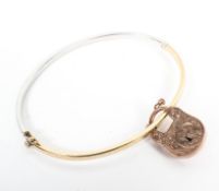 A 9ct white and yellow gold bangle bracelet together with a 9ct rose gold locket. 8.2g.