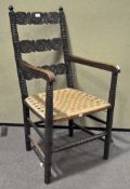 A folk art carved oak arm chair, with plaited cord seat,