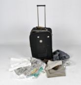A wheeled suitcase to include a la Perla shirt and other vintage ladies clothes