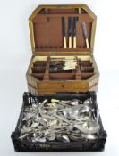 An oak two-drawer canteen and a large collection of silver-plated and stainless steel flatware