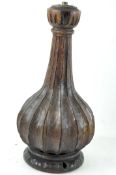 A carved wooden lamp base, of bottle form, raised on a circular base,