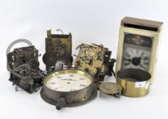 A selection of clock parts and movements, including a cased example, four loose movements,